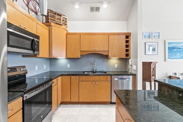 kitchen featuring a sink, dark stone countertops, visible vents, and stainless steel appliances