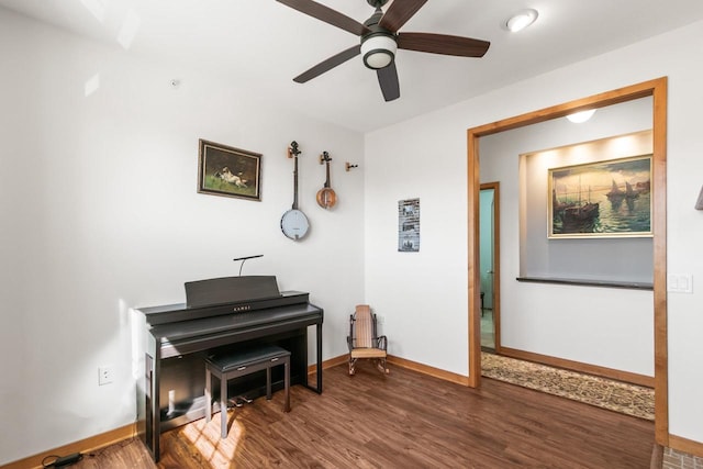 sitting room with ceiling fan, baseboards, and wood finished floors