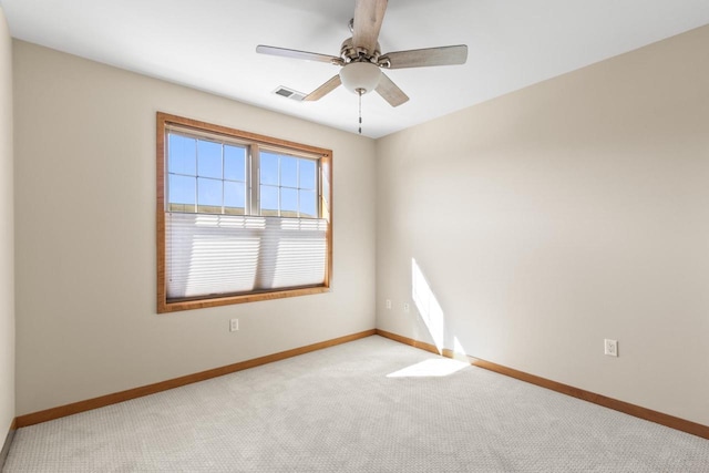 spare room featuring visible vents, baseboards, light colored carpet, and a ceiling fan