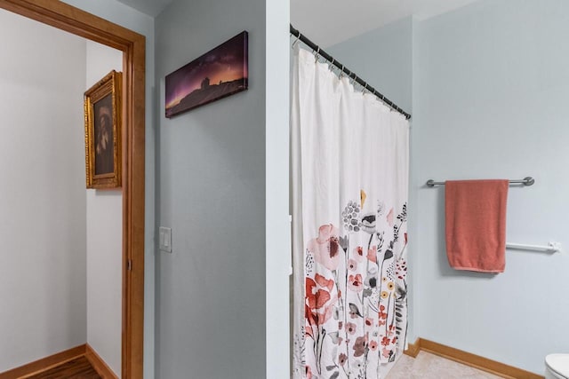 full bath with a shower with shower curtain, toilet, and baseboards