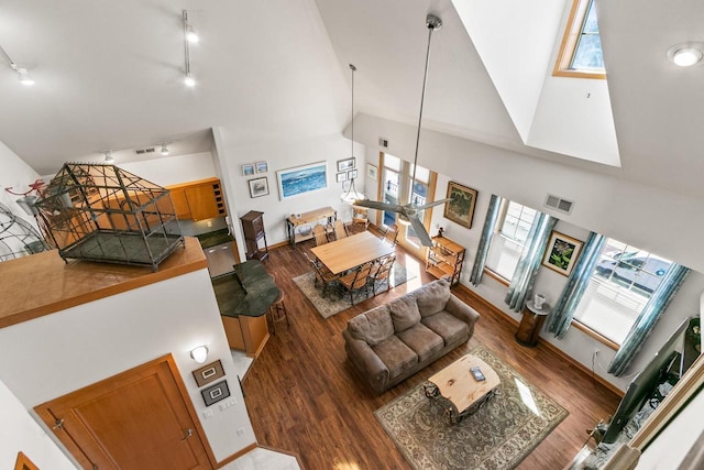 living room featuring visible vents, high vaulted ceiling, wood finished floors, and track lighting