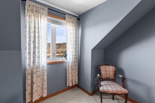 living area featuring carpet flooring, baseboards, and vaulted ceiling