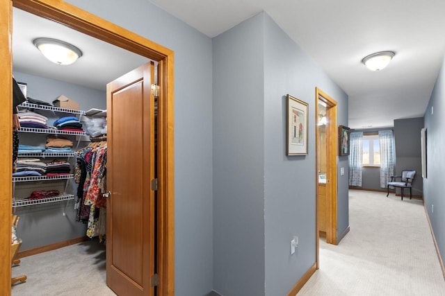 hallway featuring carpet flooring and baseboards