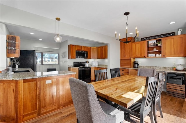 dining room with an inviting chandelier, recessed lighting, and light wood-type flooring