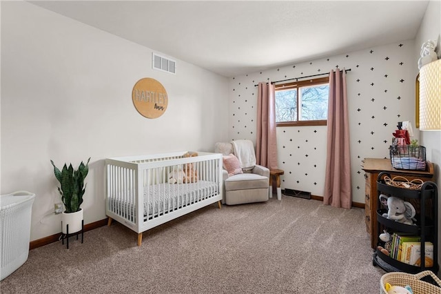 carpeted bedroom with visible vents, baseboards, a crib, and wallpapered walls