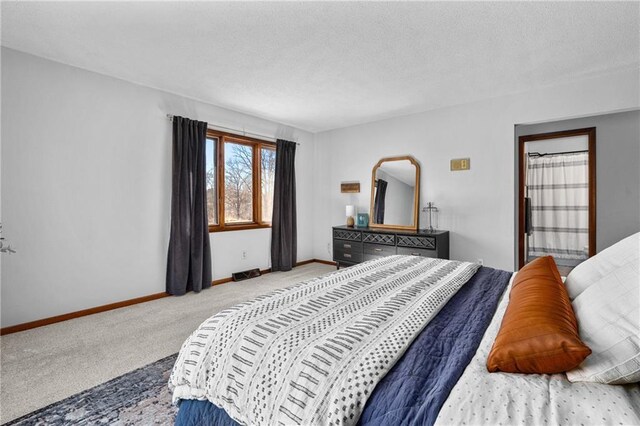 carpeted bedroom with a textured ceiling and baseboards