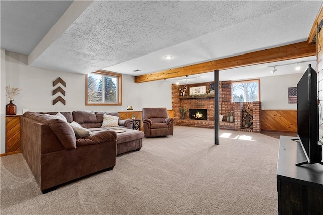 living room with beamed ceiling, a textured ceiling, wooden walls, carpet flooring, and wainscoting