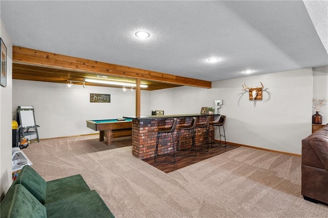 rec room with carpet, a dry bar, and a textured ceiling