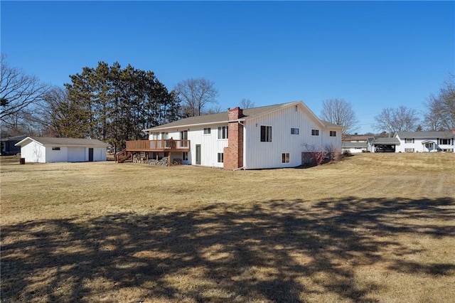 exterior space with a lawn, a chimney, a deck, an outdoor structure, and stairs