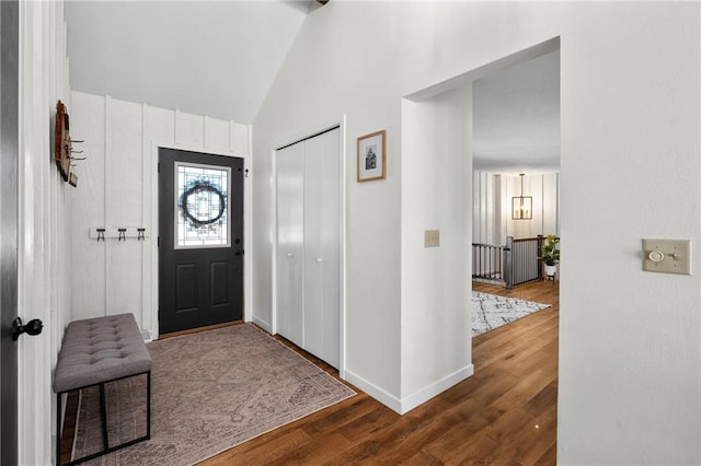 entryway featuring baseboards, lofted ceiling, and wood finished floors