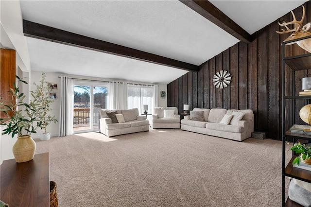 carpeted living area featuring wooden walls and lofted ceiling with beams