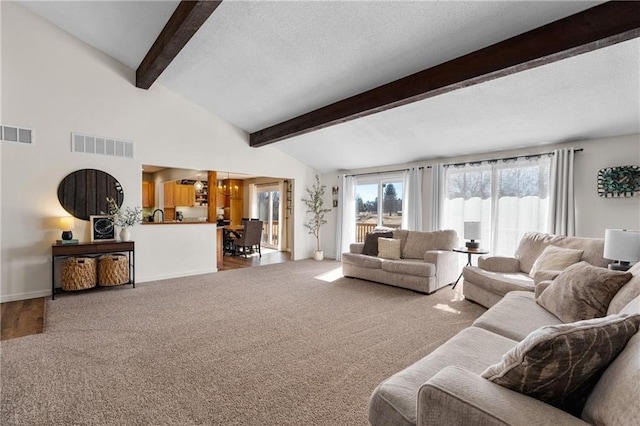 living room featuring lofted ceiling with beams, visible vents, and a textured ceiling