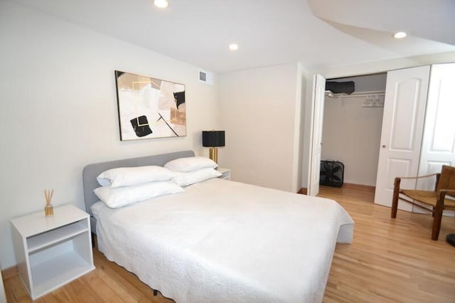 bedroom featuring light wood finished floors, visible vents, recessed lighting, and a closet