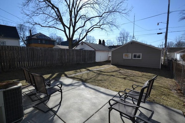 view of patio with an outbuilding, central AC unit, and a fenced backyard