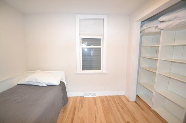 unfurnished bedroom with visible vents, baseboards, and wood finished floors