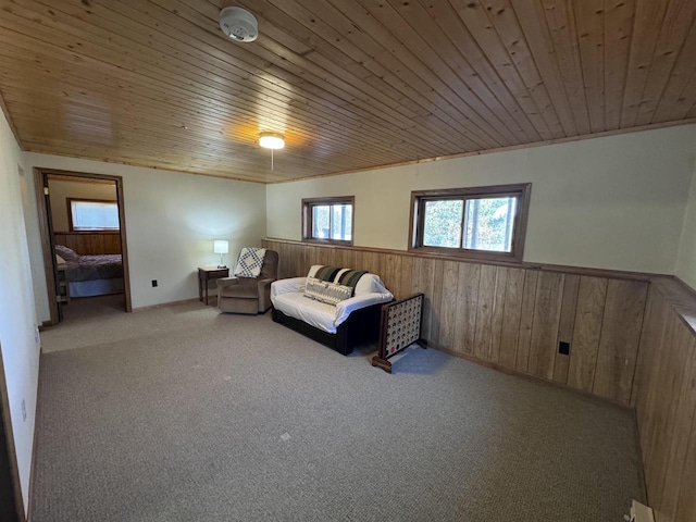 carpeted bedroom featuring wainscoting, wooden ceiling, and wood walls