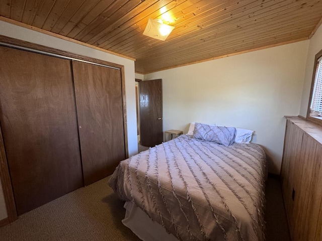 carpeted bedroom with a closet and wood ceiling