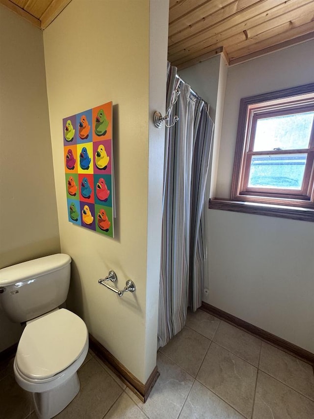 bathroom featuring tile patterned floors, baseboards, toilet, and wooden ceiling