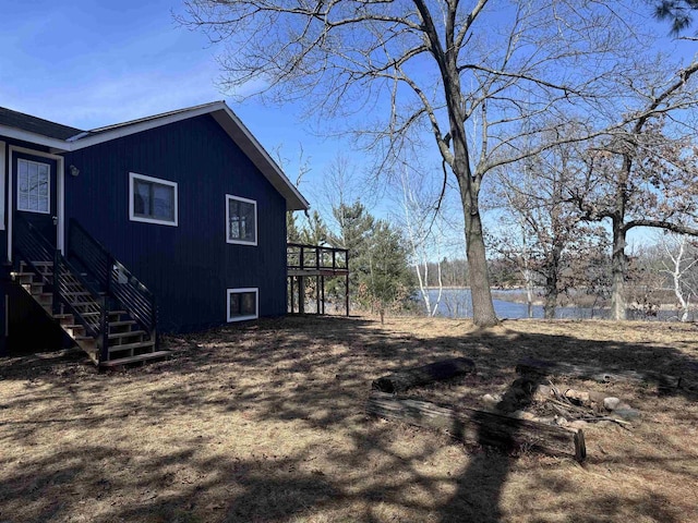 view of yard with a deck with water view and stairs