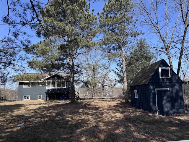 view of yard with a storage unit, an outbuilding, a wooden deck, and stairs