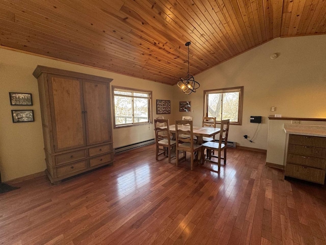 dining area featuring a baseboard heating unit, wood-type flooring, a healthy amount of sunlight, and vaulted ceiling