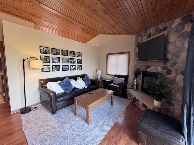 living room featuring a stone fireplace, vaulted ceiling, wood ceiling, and wood finished floors