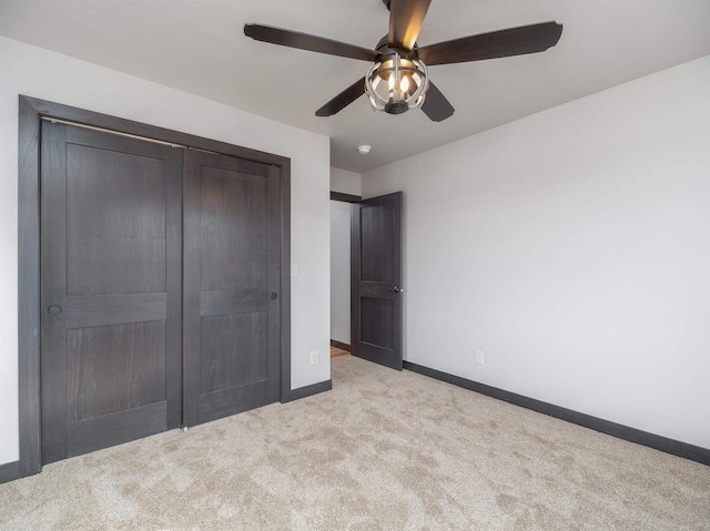 unfurnished bedroom featuring a closet, baseboards, ceiling fan, and carpet flooring