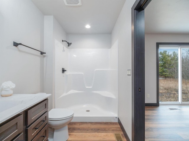 full bath featuring visible vents, toilet, wood finished floors, a shower stall, and vanity