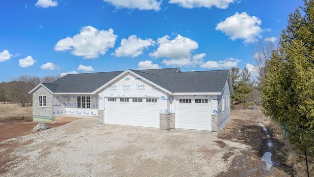 view of front of property with stone siding, an attached garage, and dirt driveway