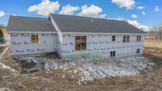 back of house with roof with shingles