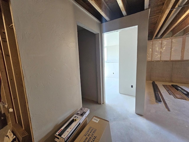 hallway with concrete floors and a textured wall
