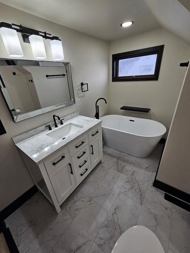 bathroom with vanity, baseboards, a freestanding tub, recessed lighting, and marble finish floor