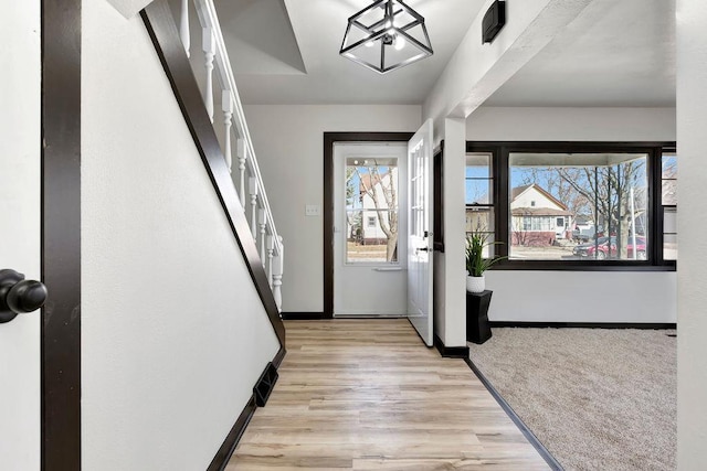 foyer entrance with wood finished floors and baseboards