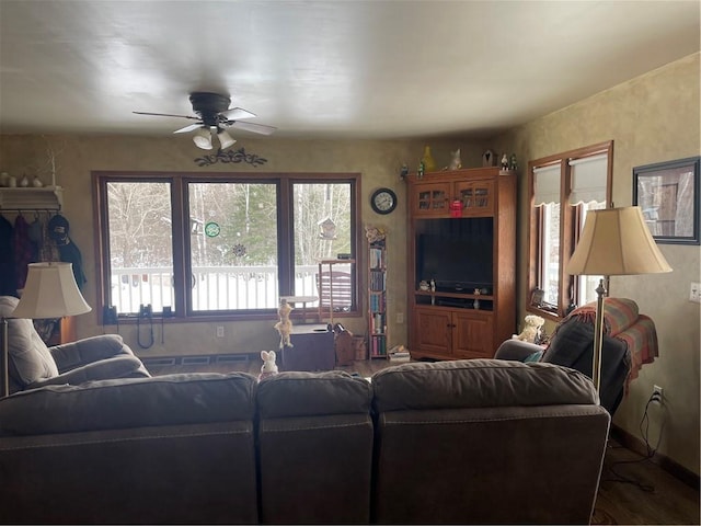 living room featuring baseboards, wood finished floors, and a ceiling fan