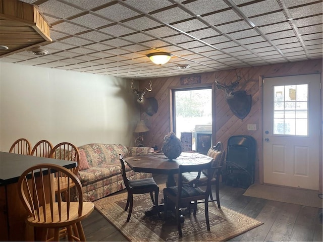 dining room featuring wood-type flooring and wooden walls