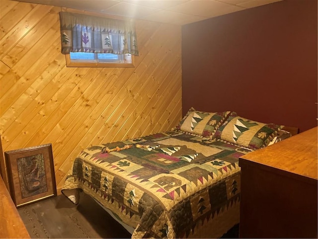 bedroom featuring wood finished floors and wood walls