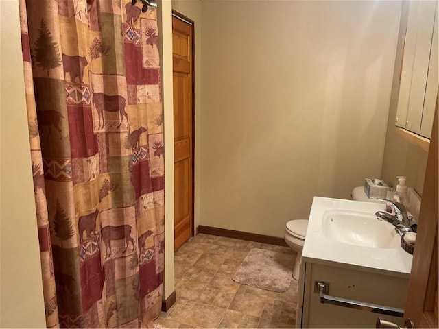 full bath featuring vanity, a shower with shower curtain, baseboards, stone finish flooring, and toilet