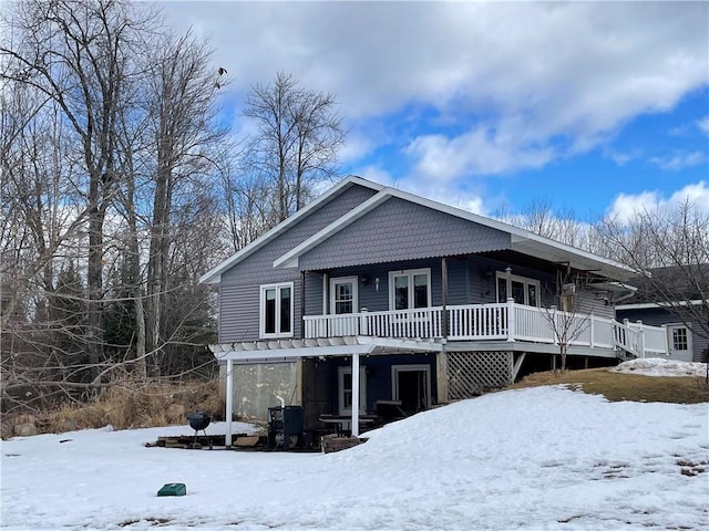 snow covered rear of property featuring a wooden deck