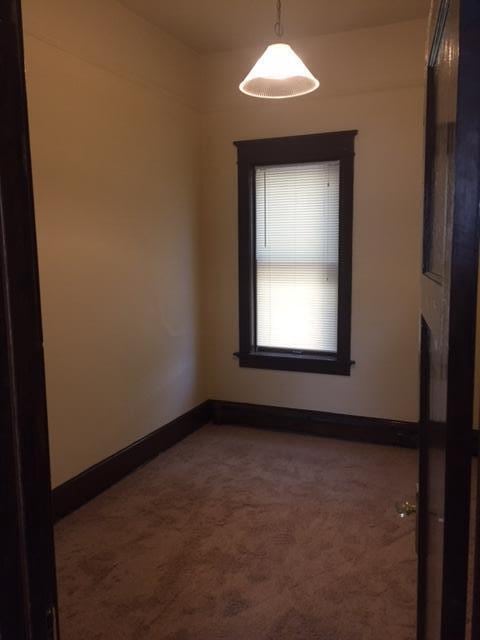 unfurnished room featuring baseboards and carpet