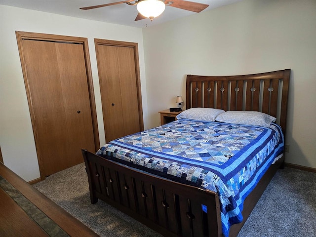 bedroom with carpet flooring, baseboards, two closets, and ceiling fan