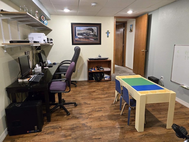 office area with wood finished floors, baseboards, and a paneled ceiling