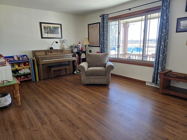 living area with baseboards and wood finished floors