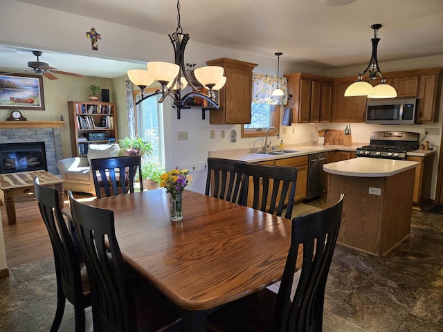 dining area featuring a glass covered fireplace and a ceiling fan