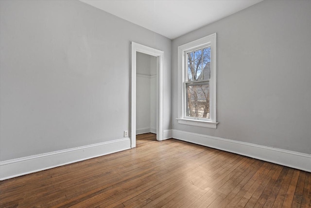 empty room with hardwood / wood-style flooring and baseboards