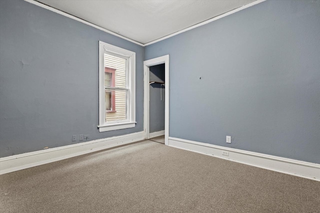 carpeted spare room with baseboards and ornamental molding