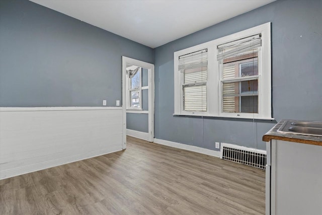 empty room featuring visible vents, baseboards, and wood finished floors