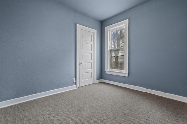 empty room featuring baseboards and carpet floors