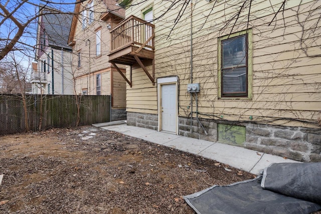 exterior space featuring a balcony and fence