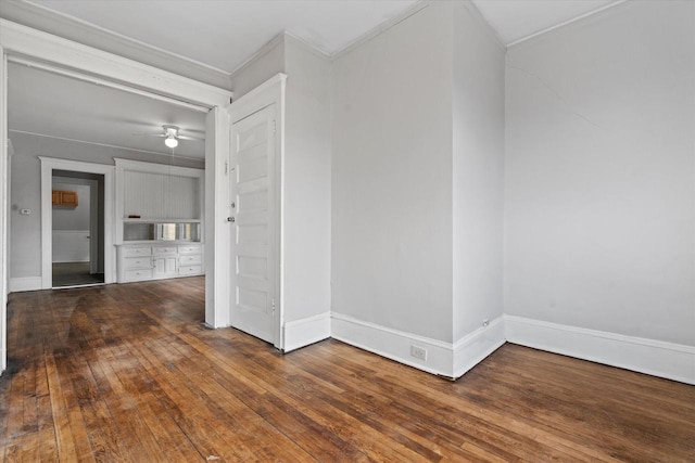 empty room featuring hardwood / wood-style flooring, a ceiling fan, and baseboards