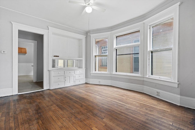 unfurnished bedroom featuring baseboards, hardwood / wood-style floors, and a ceiling fan